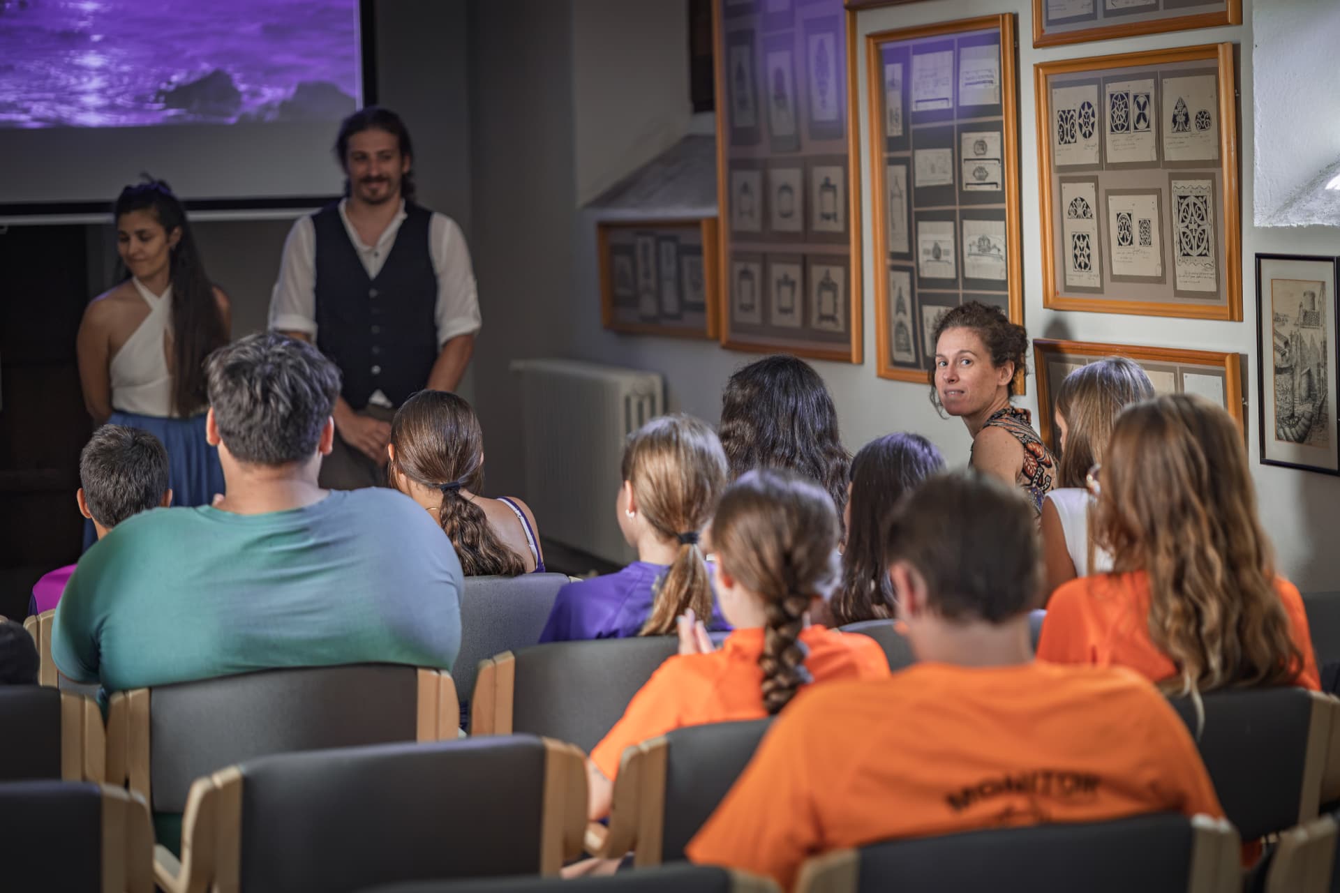Teatralització davant del grup de joves en una sala amb la projecció del vídeo